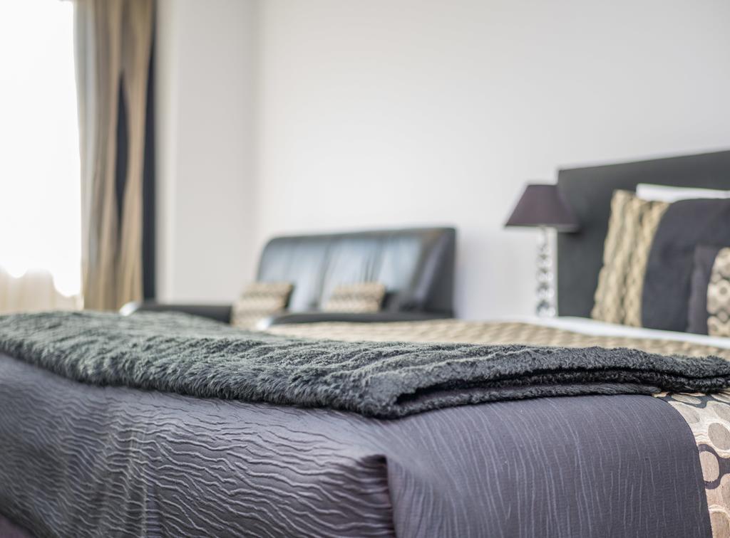 Bellano Motel Suites Christchurch Dış mekan fotoğraf A bed with a throw
